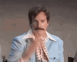a man with a mustache is wearing a blue jacket .