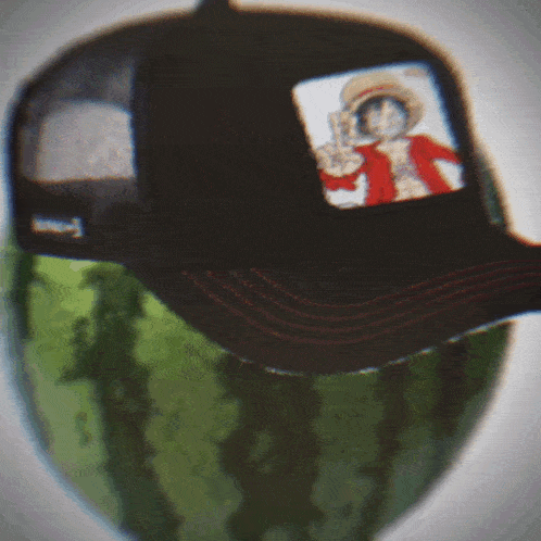 a hat with a picture of luffy on it sits on top of a watermelon