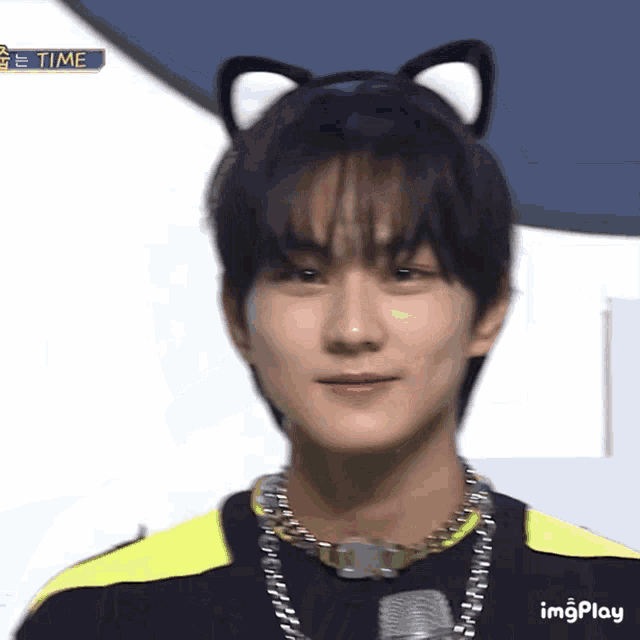 a young man wearing a cat ear headband and a microphone .