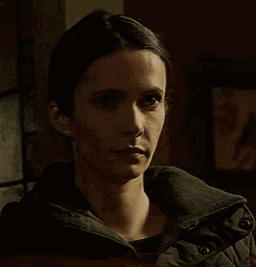 a woman is making a funny face with her mouth open in a dark room .