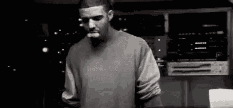 drake is smoking a cigarette in a black and white photo .