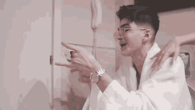 a man in a white shirt and ripped jeans is sitting on a toilet