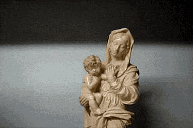 a statue of a woman holding a child on a table