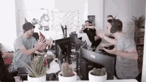 a group of people are celebrating a birthday in front of a benq monitor .