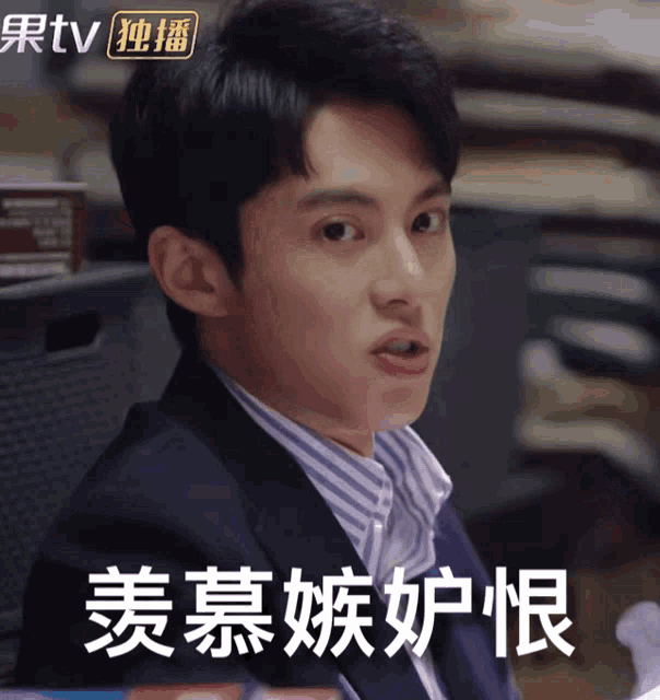 a man in a suit and striped shirt is making a funny face in chinese