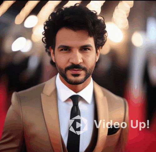 a man in a suit and tie is standing in front of a video up sign