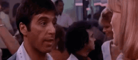 a man and a woman are talking to each other at a party .