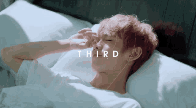 a person laying on a bed with the word third written above them
