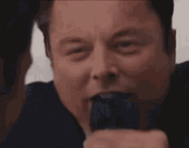 a man in a suit and tie is making a funny face with his mouth open .