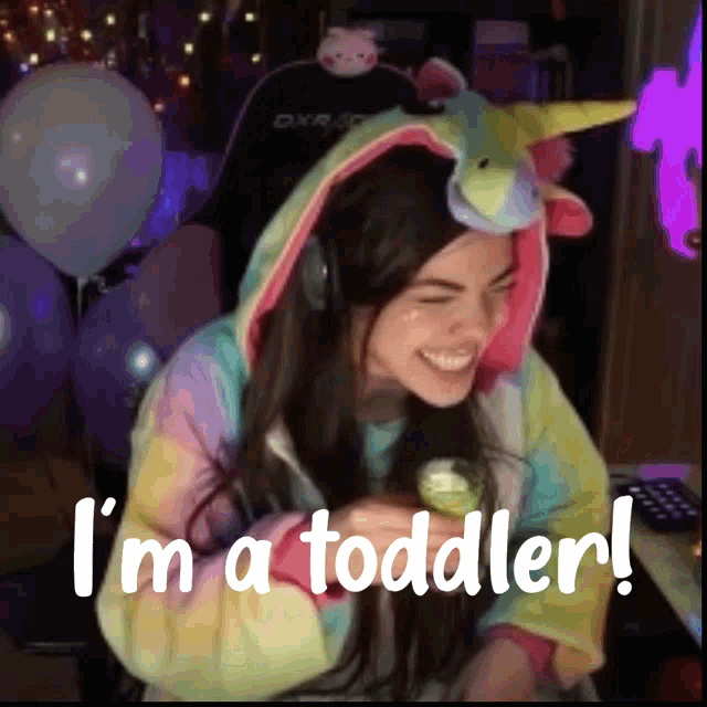 a woman in a unicorn costume is smiling and says i 'm a toddler