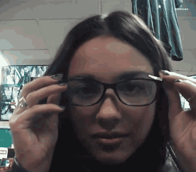 a close up of a woman wearing glasses with the word archives in the upper right corner