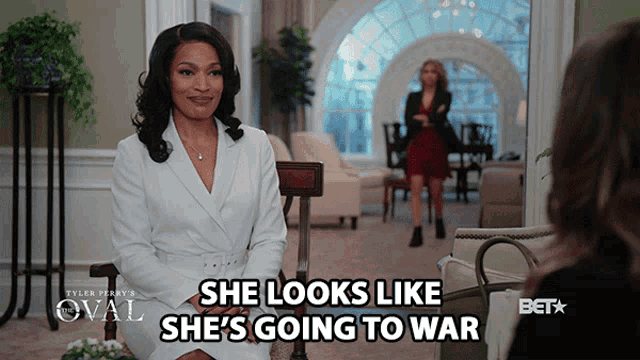 a woman sitting in a chair with the words she looks like she 's going to war below her