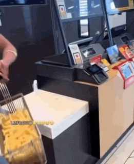 a woman is making french fries at a mcdonald 's restaurant .