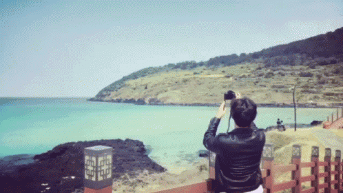 a person taking a picture of a body of water