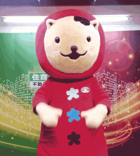 a stuffed animal in front of a green sign that says ' 住 商 不動 '