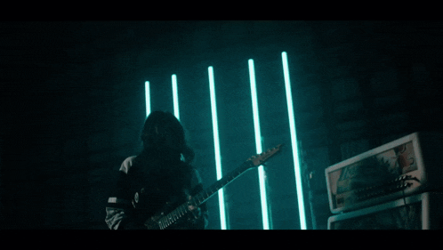 a woman plays a guitar in front of a marshall amp