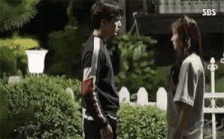 a man and a woman are standing next to each other in front of a house .