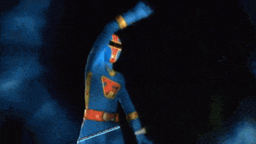 a blue superhero is standing in the dark with his arms outstretched and the word hurricane written above him .