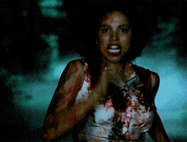 a woman in a bloody dress is screaming and looking at the camera