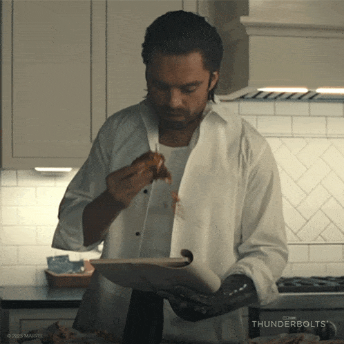 a man in a white shirt is holding a plate of food with thunderbolts written on the bottom