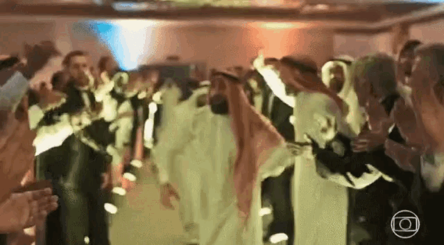 a group of people are dancing in a room with a circle in the middle