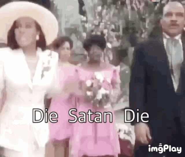a woman in a pink dress is walking down the aisle with a man in a suit .