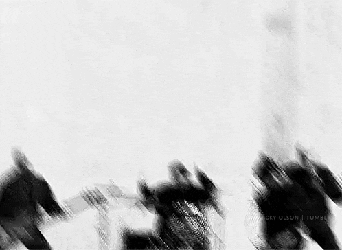 a black and white photo of a group of people standing in front of a white wall .