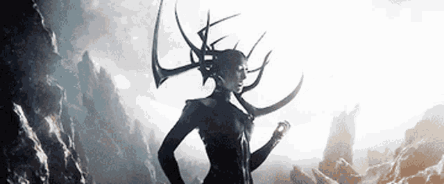 a woman with horns on her head is standing in the middle of a mountain .