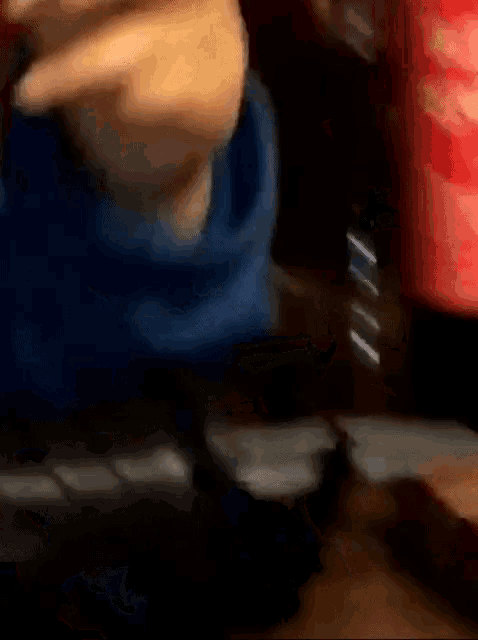 a bottle of coca cola sits on a table next to a person 's hand