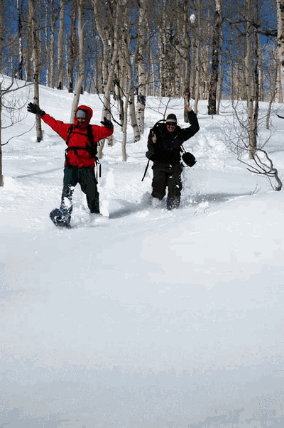 a man in a red jacket is snowboarding in the snow