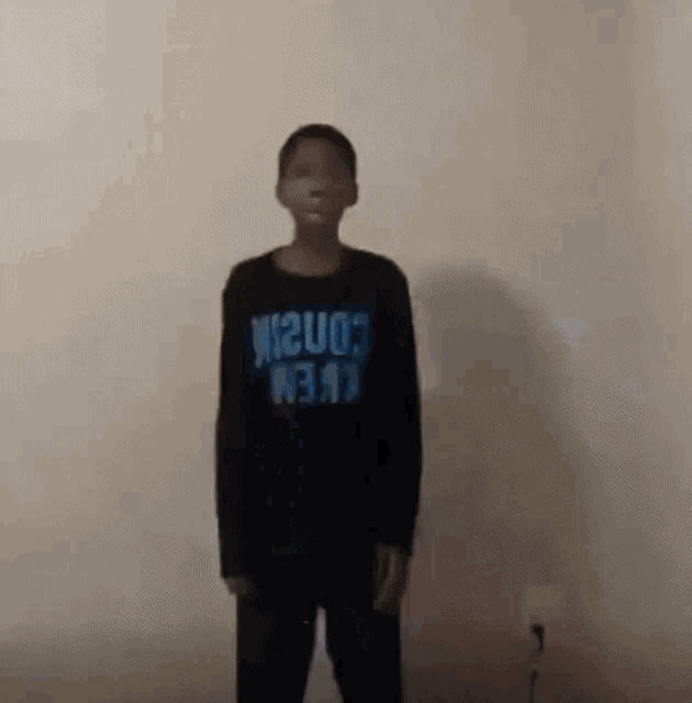 a young boy wearing a black shirt that says ' crew ' on it