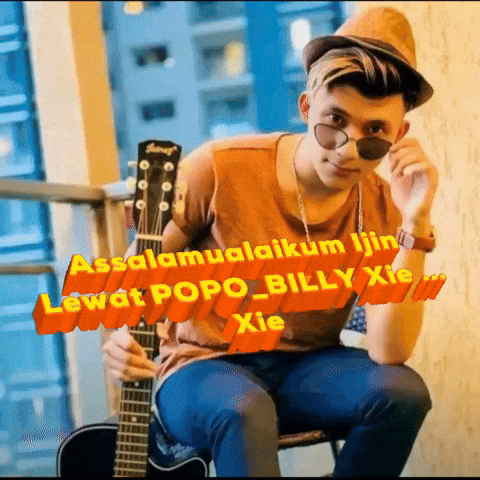 a young man is holding a guitar and wearing a hat