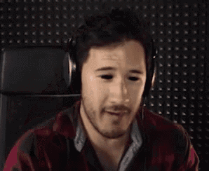 a man wearing headphones holds his hand to his forehead and says but then again