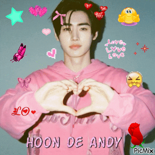 a man in a pink hoodie making a heart with his hands