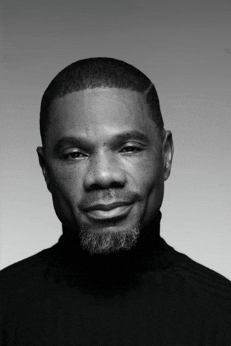a man with a beard is wearing a black turtleneck sweater