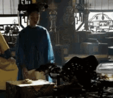 a woman in a blue robe is standing in a room with a man in a yellow robe