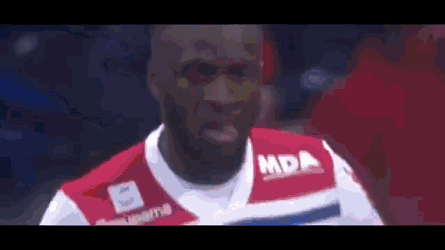 a man wearing a red and white jersey with the word mda on the front