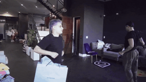 a man in a black shirt is carrying a bag that says balenciaga
