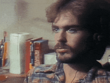 a man in a plaid shirt is looking at something in front of a dictionary