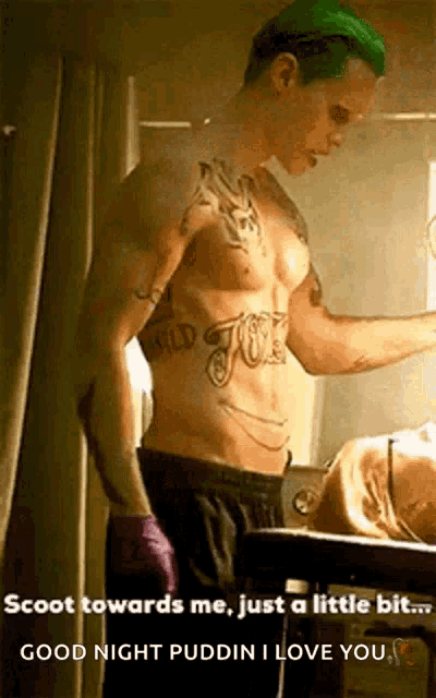 a shirtless man with green hair is standing next to a woman in a bathroom .