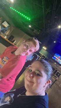 a man and a woman are posing for a selfie in a bar