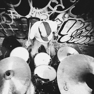 a black and white photo of a man playing drums