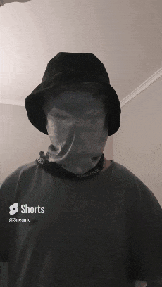 a person wearing a bucket hat and a shirt that says shorts on it