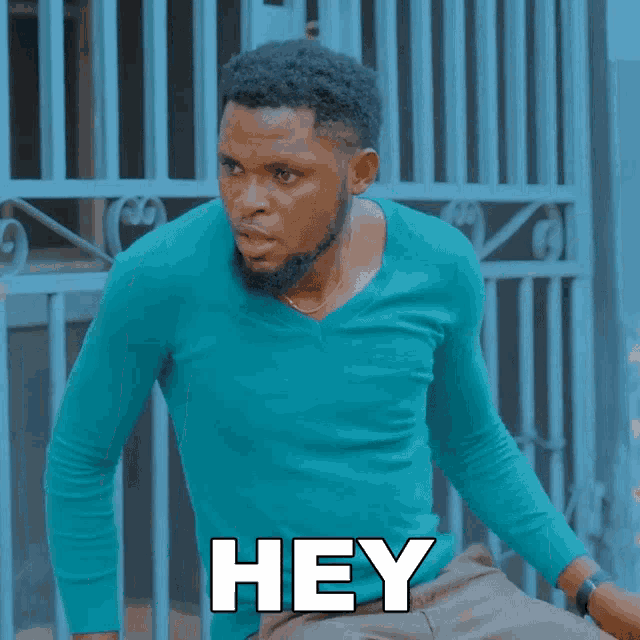 a man in a blue shirt has the word hey on his chest