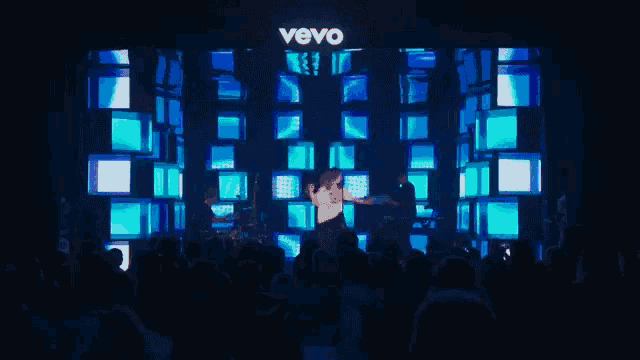 a man is dancing on a stage in front of a vevo sign