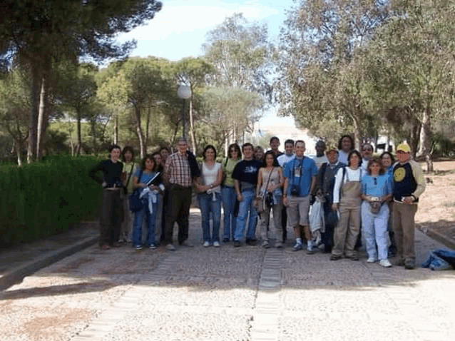a group of people are posing for a picture in a park with trees