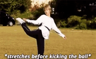 a man is stretching his leg before kicking a ball .