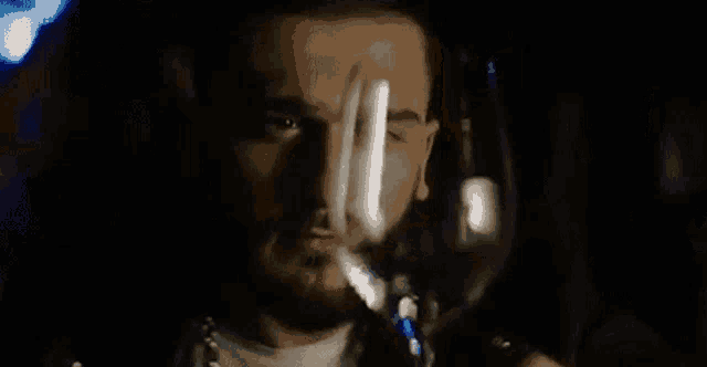 a man with a beard is holding a glass of wine .