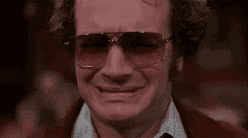 a close up of a man wearing sunglasses and making a face .
