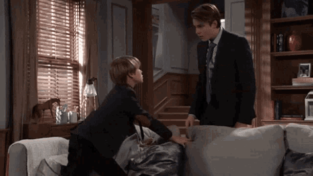 a man in a suit and tie is standing next to a boy in a suit and tie